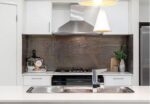 Glossy mosaic tiles in this kitchen, reminiscent of interiors found in Balmain, provide a striking backdrop